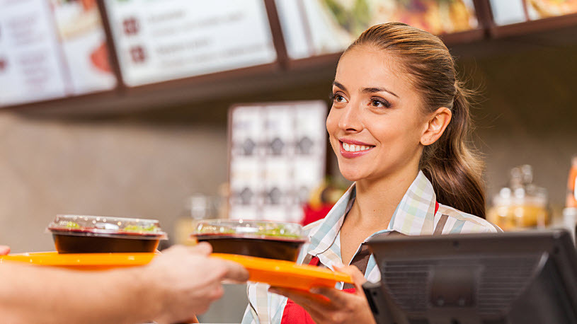 Restaurant worker serving tray of fast food across counter Restaurant worker serving tray of fast food across counter