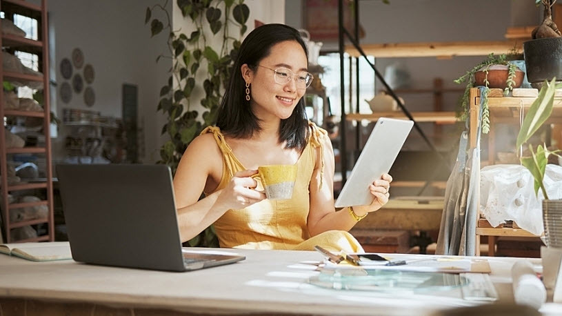 Asian woman business owner at desk with tablet and computer Asian woman business owner at desk with tablet and computer