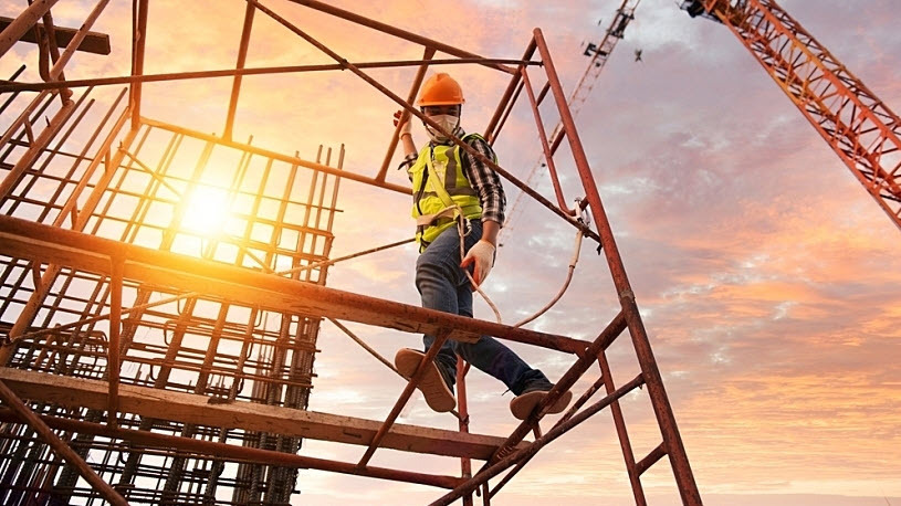 worker in hard hat walking on scaffolding worker in hard hat walking on scaffolding