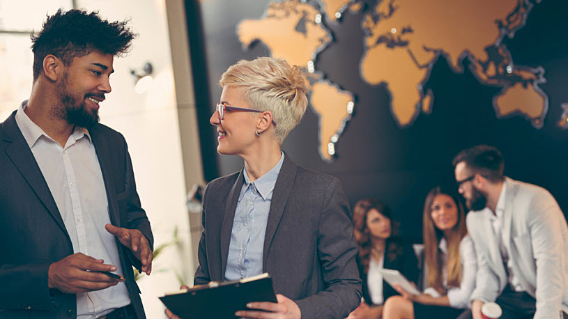 Global Payroll Team members talk in a global office lobby