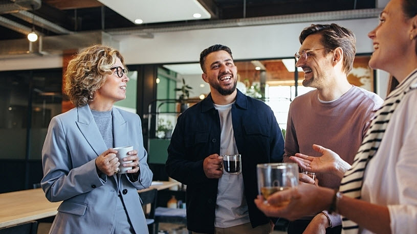 happy colleagues older and younger chatting over coffee happy colleagues older and younger chatting over coffee