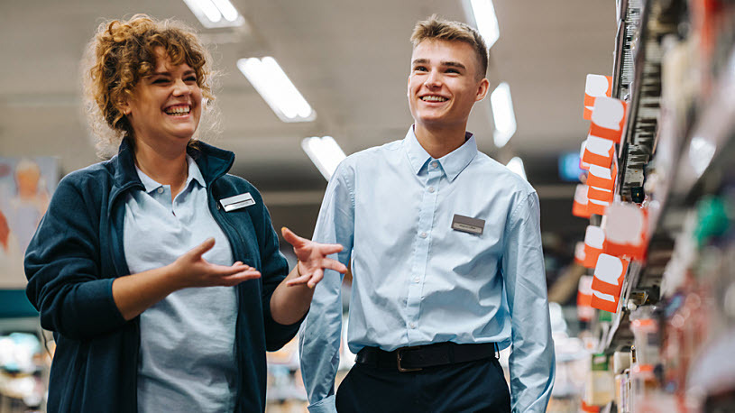 Local grocery store manager training new hire in aisle Local grocery store manager training new hire in aisle