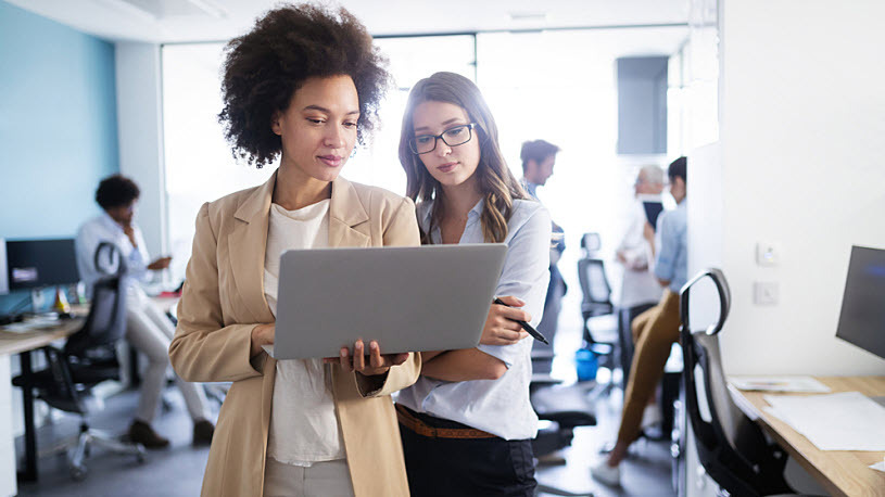 Two young businesswomen in casual office planning work Two young businesswomen in casual office planning work