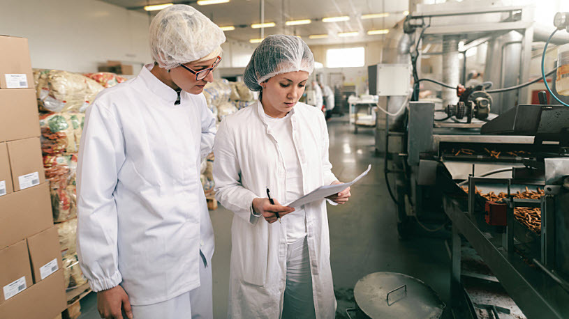 Two quality control technicians review research results in lab Two quality control technicians review research results in lab