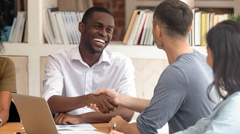 Happy Black businessman shaking hand of white male coworker Happy Black businessman shaking hand of white male coworker