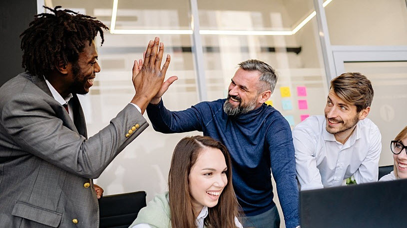 2024 Trends in HR technology Two people high-five each other in an office.