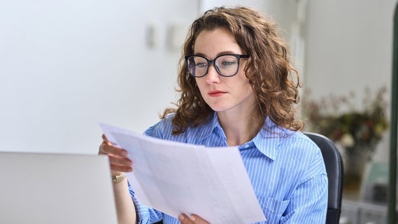 California Pay Transparency Law A businesswoman reviews paperwork in an office.