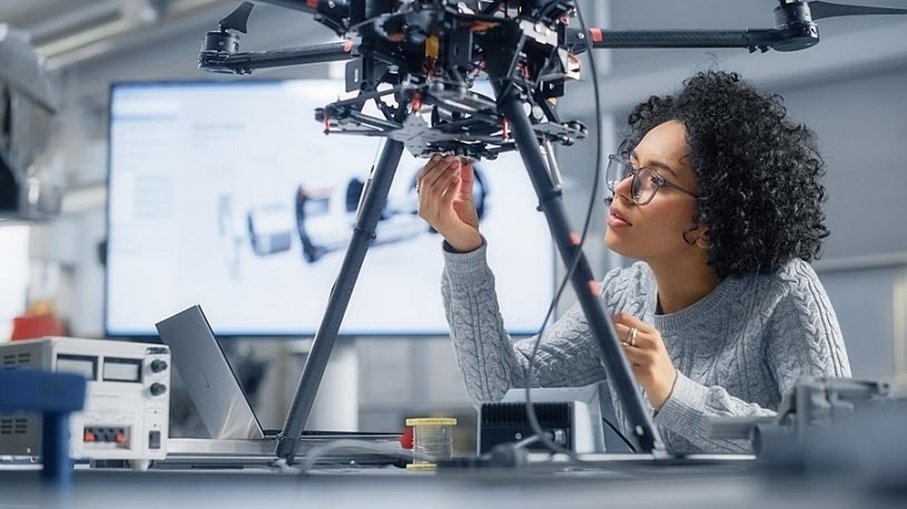Concentrated female engineer testing new technology in lab Concentrated female engineer testing new technology in lab