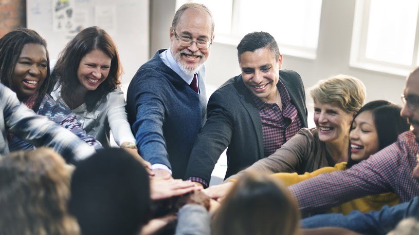 Workers in an office participating in a team huddle An Overview of Inclusion in the Workplace
