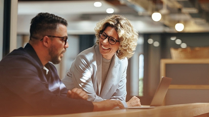 Image of smiling woman and man in co-working space How Generative AI Is Enhancing HR and the Human Experience