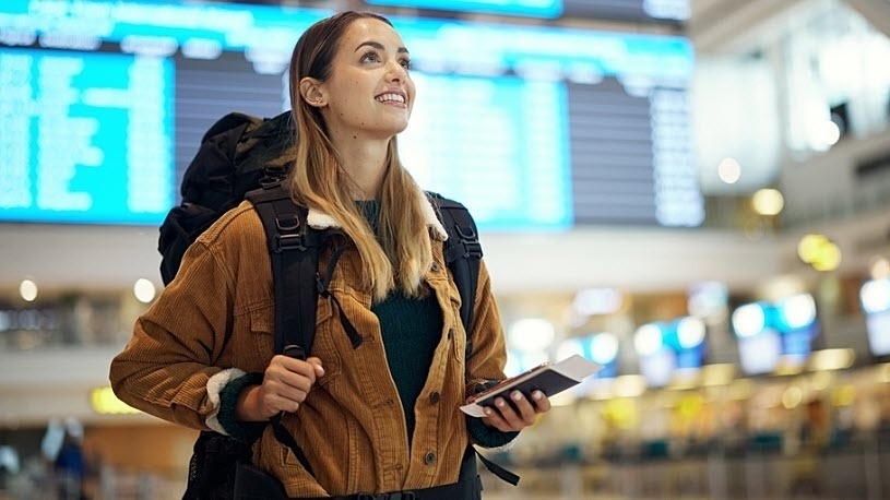 Photo of young woman with backpack in airport with travel docs Photo of a young woman with a backpack in an airport with travel docs