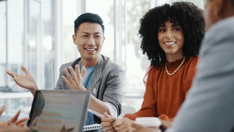 Career Transition Coworkers gather at an office conference table for a meeting.