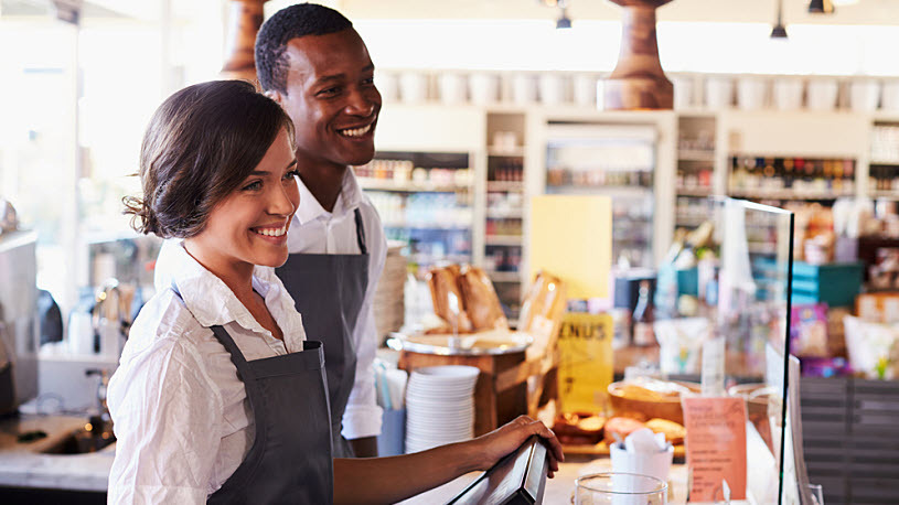 Young smiling deli workers serving customers at the counter Young smiling deli workers serving customers at the counter