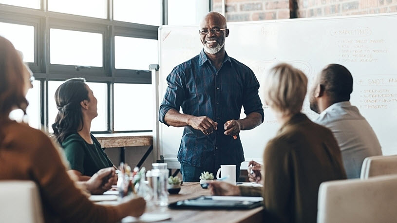 Manager addresses diverse team about workforce trends Shot of a businessman giving a presentation to his colleagues in a boardroom