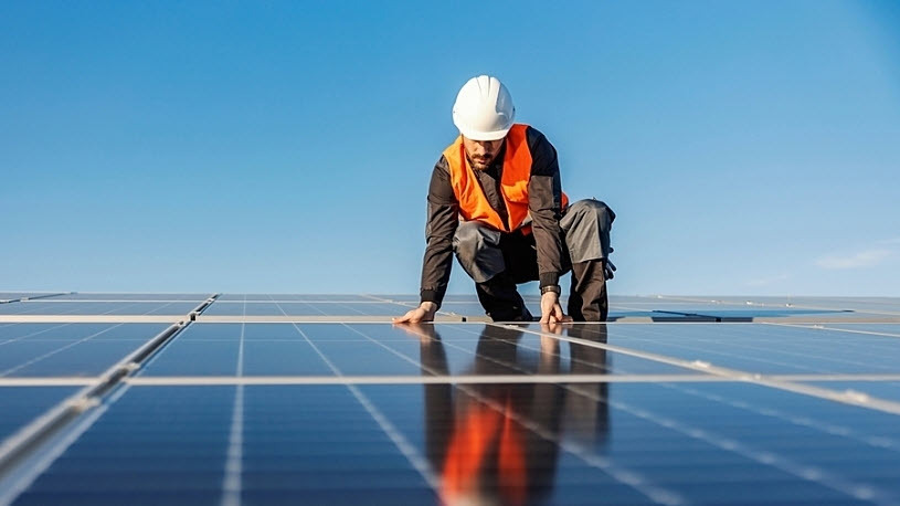 Photo of a worker installing solar panels