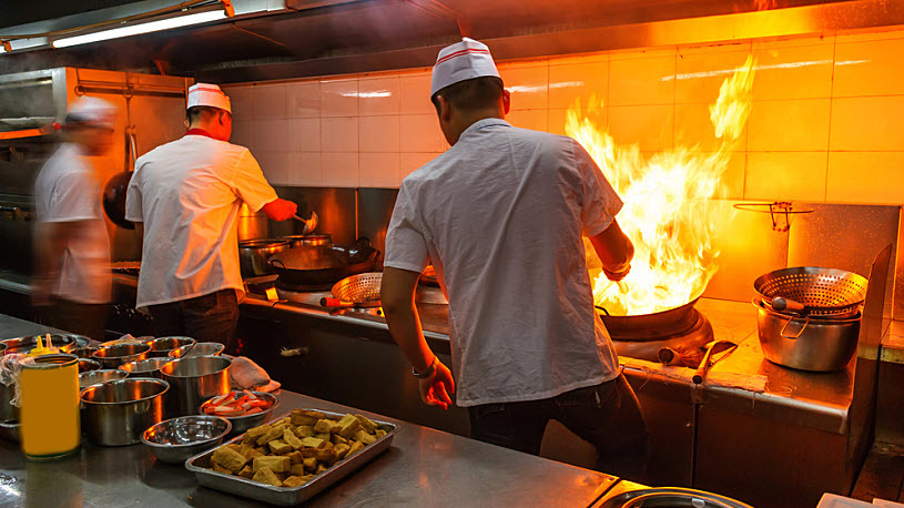 Photo of crowded kitchen with three chefs working at hot stove Photo of crowded kitchen with three chefs working at hot stove