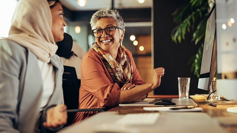 Two office workers smiling and enjoying themsleves