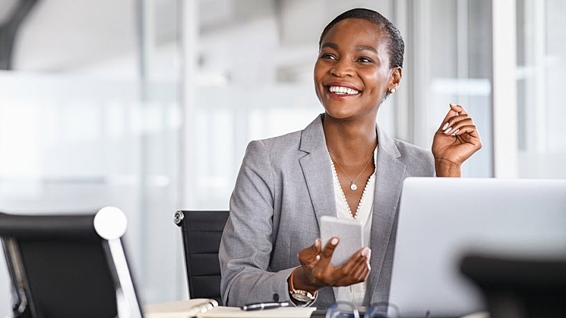 Black woman finance leader sitting at conference table smiling Black woman finance leader sitting at conference table smiling
