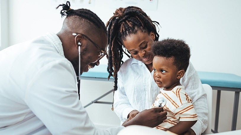 A happy toddler boy sits in his mother' lap at the pediatrician Decoding High-Deductible Health Plans (HDHPs) and HSA-Compatible Plans