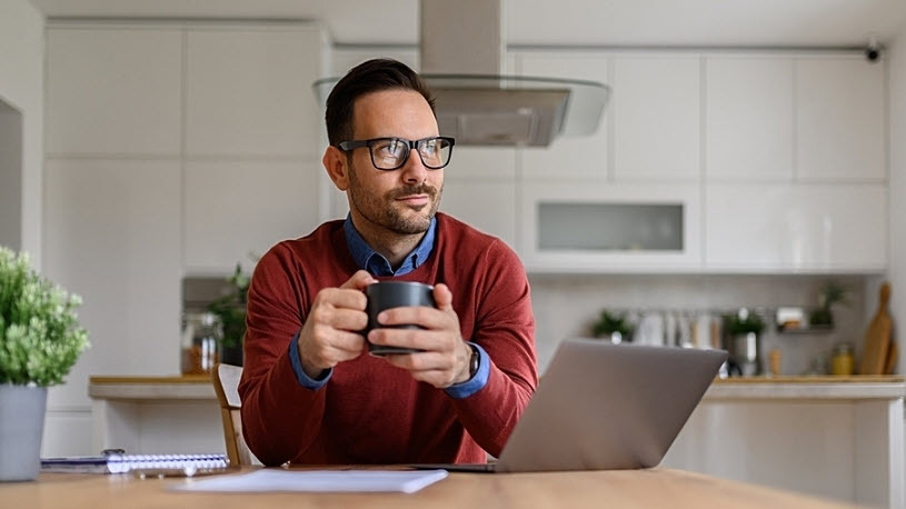 White male holds coffee mug at kitchen table pensive White male holds coffee mug at kitchen table pensive