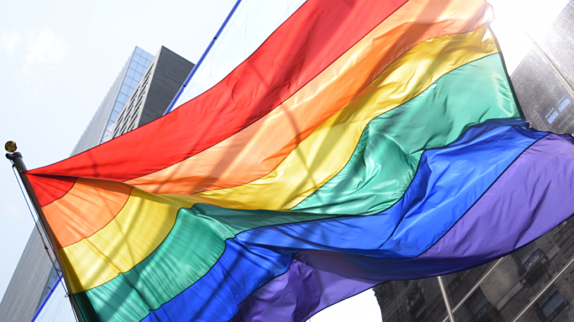 Celebrating Pride in the Workplace A rainbow Pride flag waving in the wind.