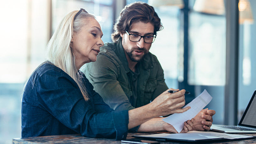 mature businesswoman and young man discuss compliance measures mature businesswoman and young man discuss compliance measures
