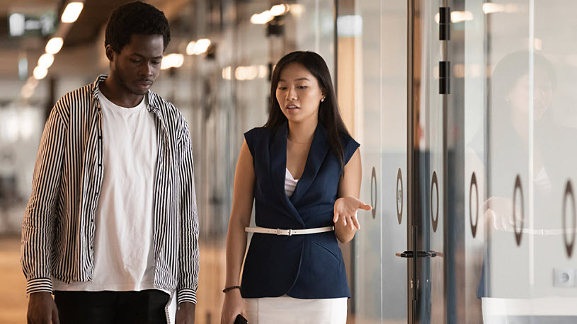 Manager and team member walking and having serious chat Manager and team member walking and having serious chat