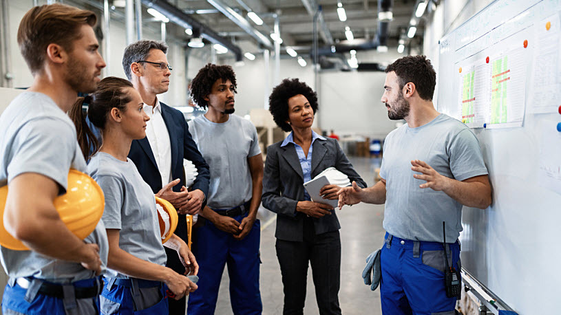 Group of diverse warehouse workers in team meeting with manager Group of diverse warehouse workers in team meeting with manager