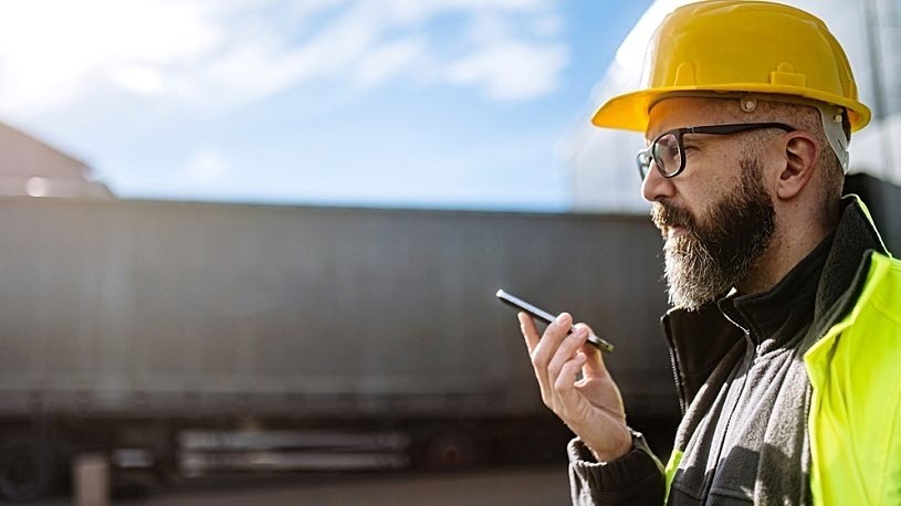male warehouse worker waiting for delivery and talking on phone male warehouse worker waiting for delivery and talking on phone