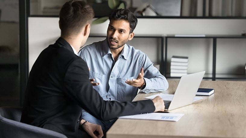 Serious young Indian businessman discussing general liability ins Serious young Indian businessman discussing general liability insurance with broker