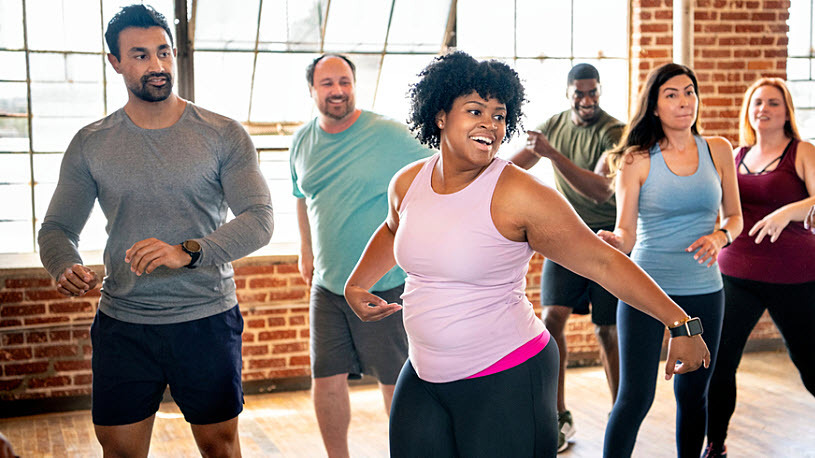 Unique Employee Benefits Diverse employees in an active dance class at work