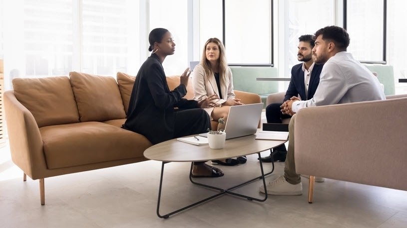 Young professional Black woman talks to diverse team in office Young professional Black woman talks to diverse team in comfortable office
