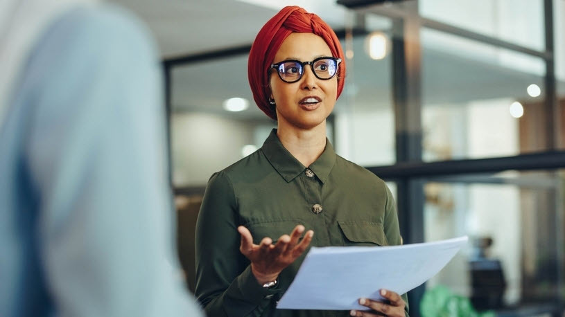 Inclusive Workplace A person wearing a turban makes a presentation to co-workers.