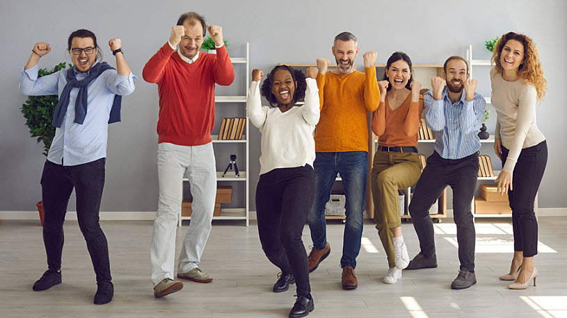 Gamification in the Workplace Group of coworkers cheering, fist pumping and having fun in modern office