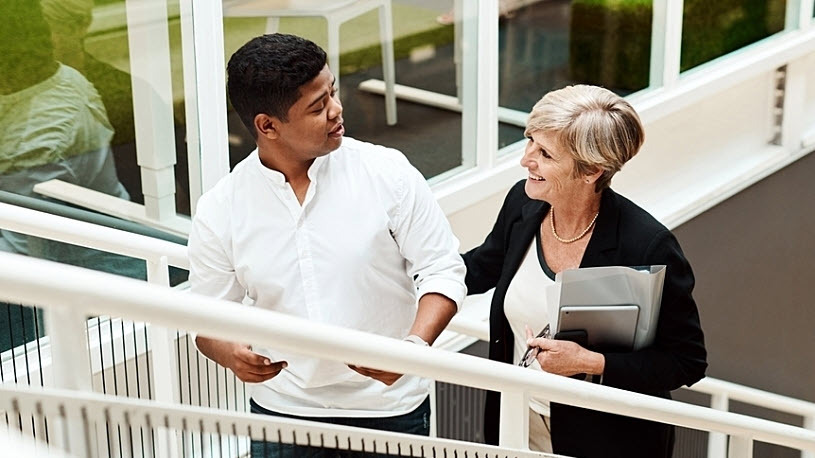 Employee talks to senior manager while walking up stairs Employee talks to senior manager while walking up stairs
