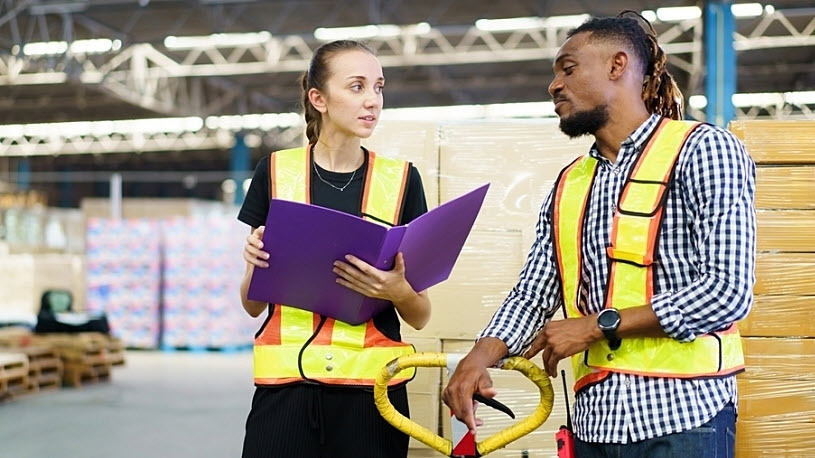 Warehouse manager talks casually with team member Warehouse manager talks casually with team member