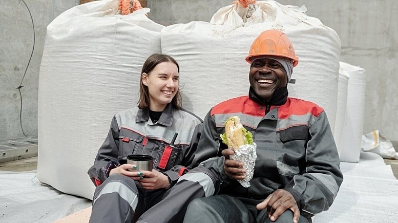 Cheerful construction workers taking a break at worksite Construction workers taking a break at worksite