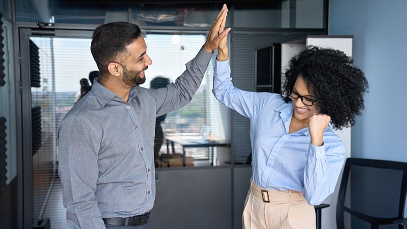 5 Reasons You Need Compliance Technology Two coworkers high five in celebration of compliance win