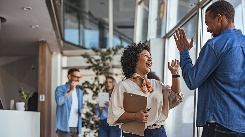 Smiling colleagues exchange high fives in modern office Smiling colleagues exchange high fives in modern office