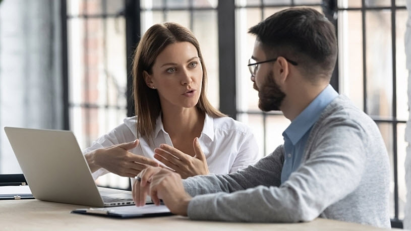 Man and woman coworkers discussing ACA penalty avoidance at work Common Trends in ACA IRS Errors and the Recommended Response Process