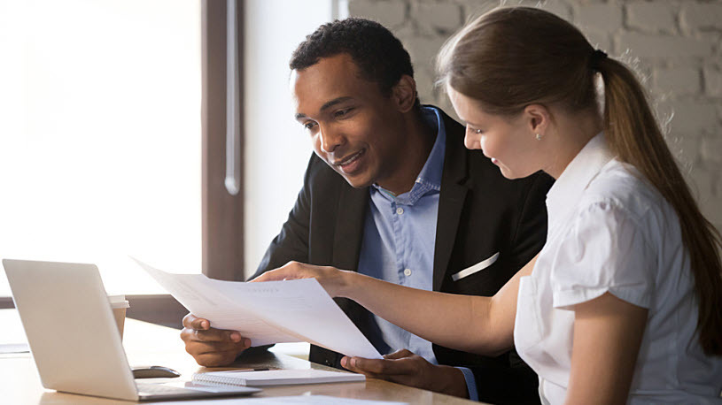 HR leader consults with benefits manager on new technology Smarter Benefits Technology: The Key to Accuracy, Efficiency, and Employee Satisfaction