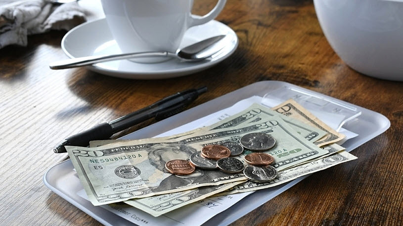 cash tip left with bill and coffee cup at cafe New Tax Deductions and Employer Responsibilities Per H.R.1, the One Big Beautiful Bill Act
