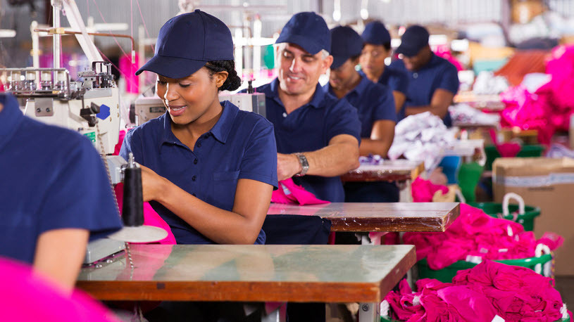 diverse group of factory workers seated in rows in workspace H.R.1 Impacts to Taxes on Overtime and Tips: What Employers Need to Know