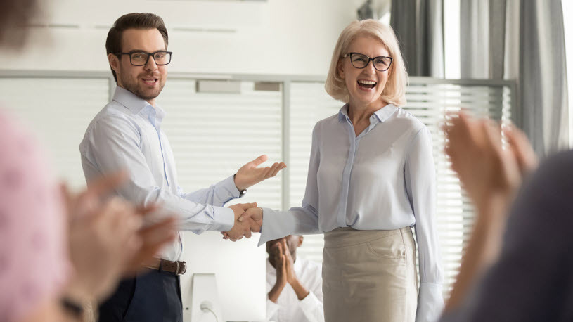 Motivating and Rewarding Employees Manager congratulates a top employee with handshake.