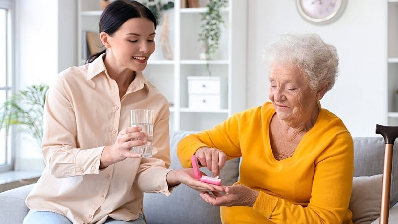 Senior woman with her daughter taking pills at home Senior woman with her daughter taking pills at home