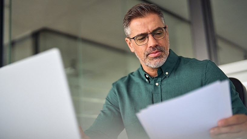 Small business owner reviews workers' compensation insurance data Small business owner reviews workers' compensation insurance data to prepare for audit
