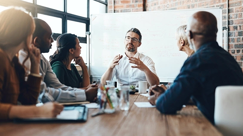 Investment manager meets in boardroom with company benefits team Investment manager meets in boardroom with company benefits team