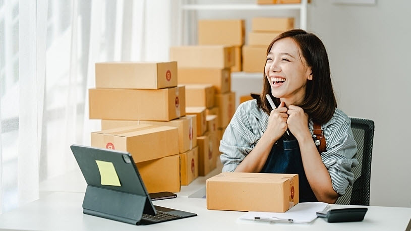 Small business owner smiling using HR technology Small business owner smiling using HR technology