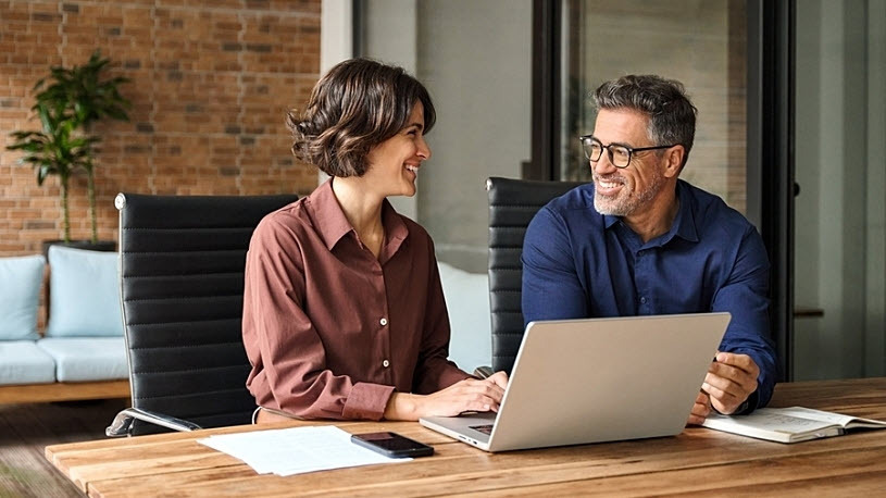 Two smiling retirement plan benefit administrators meeting to discuss catch-up contributions