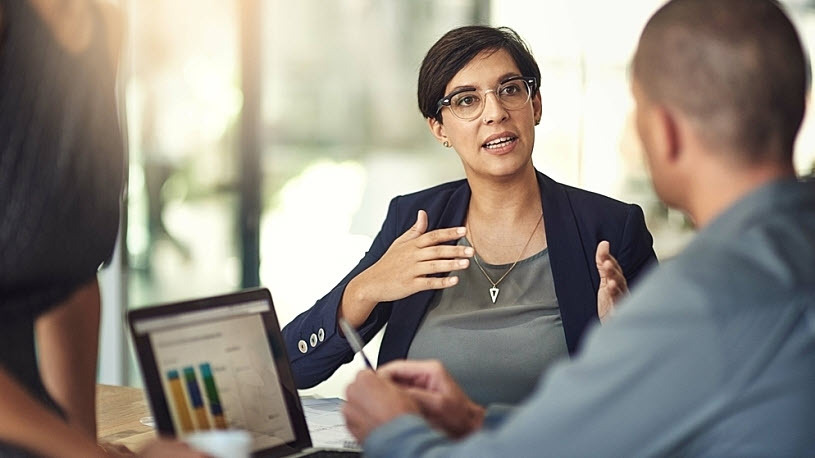 Mature female manager at conference table offering feedback Mature female manager at conference table offering feedback